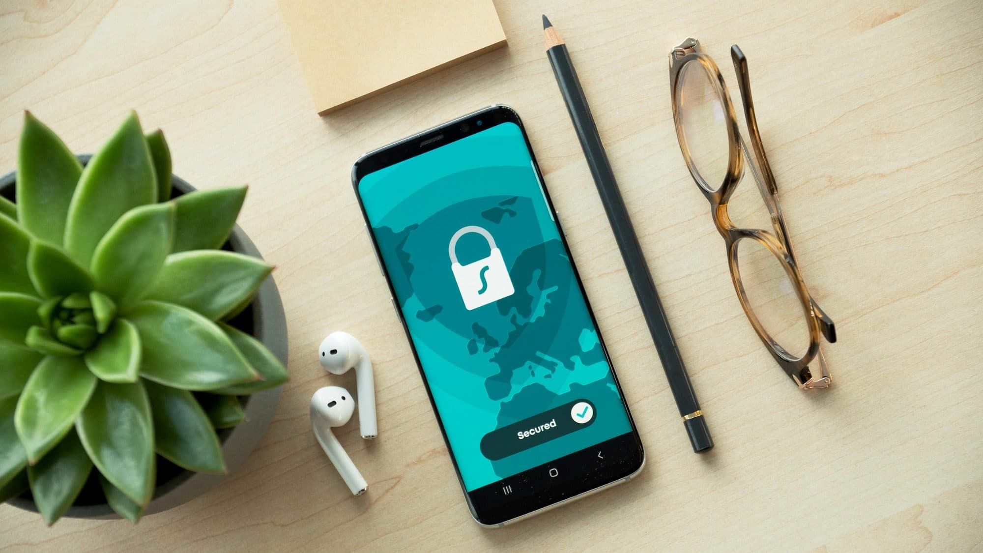A phone showing a padlock security screen on a desk